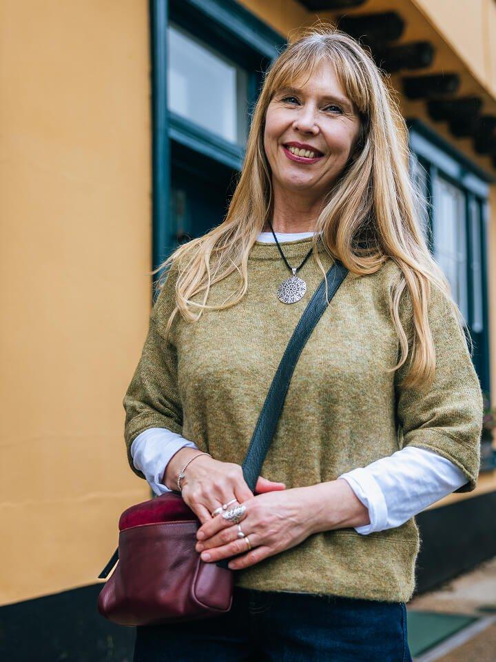 a woman standing outside of a building with a purse